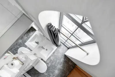 a bathroom with a white toilet and a window at Piano Apartments in Kaunas