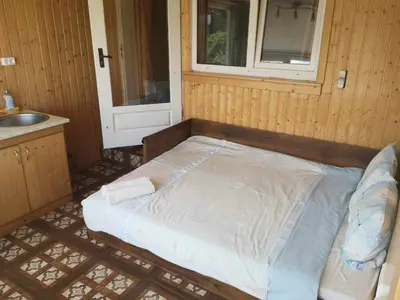 a bed in a room with a window and a sink at Griežto 5 in Zarasai