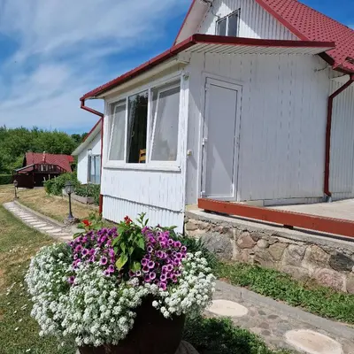 a small house with flowers in front of it at Griežto 5 in Zarasai
