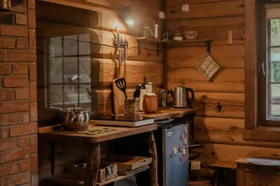 a kitchen with wooden walls and a stove top oven at Pirtelė dviem in Kulionys
