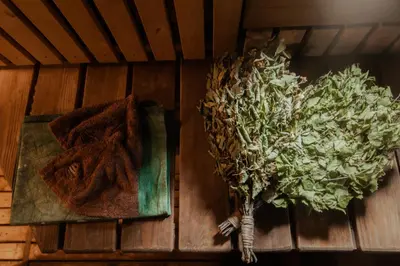a wooden table with a towel and a plant on it at Pirtelė dviem in Kulionys