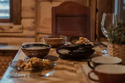 a wooden table with plates of food on it at Pirtelė dviem in Kulionys