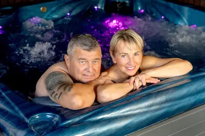 a man and a woman in a swimming pool at Butenas Hotel Tyla in Biržai