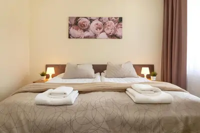 a bedroom with a large bed with two towels on it at Butenas Hotel Tyla in Biržai