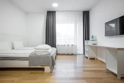 a white bedroom with a bed and a window at #draugunamai in Druskininkai