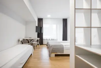a hotel room with two beds and a table at #draugunamai in Druskininkai