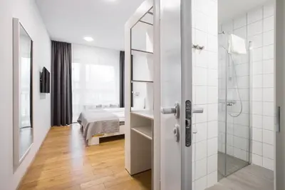 a bathroom with a shower and a bed in a room at #draugunamai in Druskininkai
