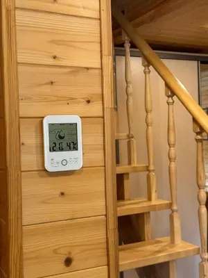 a clock on a wooden wall next to a staircase at Apartamentai Renata in Druskininkai