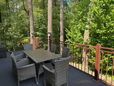 a wooden table and chairs on a deck at Apartamentai Renata in Druskininkai