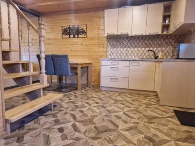 a kitchen with a table and a sink and a counter at Apartamentai Renata in Druskininkai