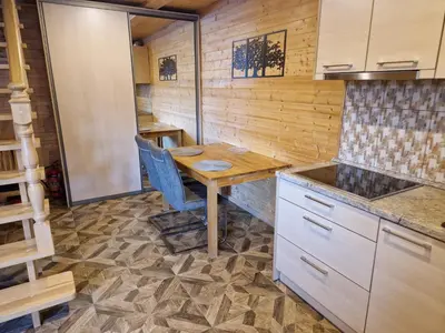 a kitchen with a wooden table in a room at Apartamentai Renata in Druskininkai