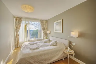 a bedroom with a large bed and a window at Penthouse in Druskininkai