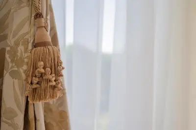 a broom hanging on a curtain next to a window at Penthouse in Druskininkai