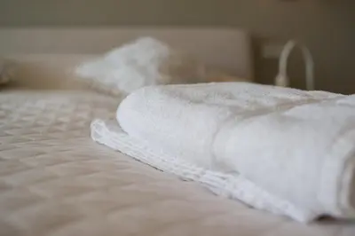 two white towels sitting on top of a bed at Penthouse in Druskininkai