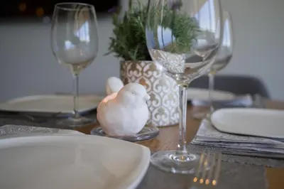 a table with wine glasses and a bird on it at Penthouse in Druskininkai