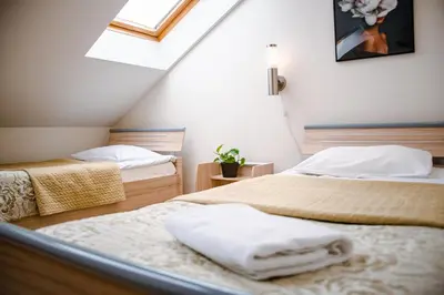 a bedroom with two beds and a skylight at Hotel Pas Katina in Panevėžys