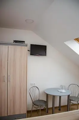 a room with a table and chairs and a tv at Hotel Pas Katina in Panevėžys