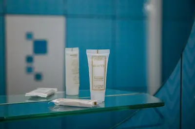 two bottles of moisturizing cream on a glass table at Hotel Pas Katina in Panevėžys