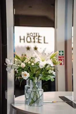a vase filled with white flowers on a table at Hotel Pas Katina in Panevėžys