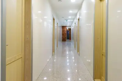 a corridor of a building with white walls and white floors at Hotel Pas Katina in Panevėžys