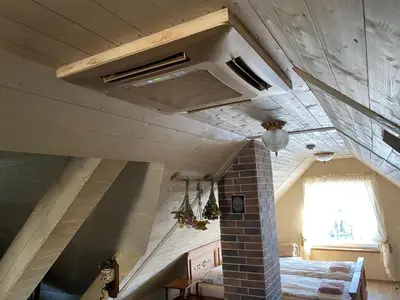 a room with a brick fireplace and a ceiling at Arbatinės apartamentai in Biržai