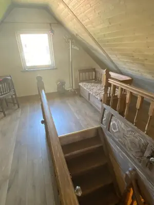an attic room with a bed and a window at Arbatinės apartamentai in Biržai