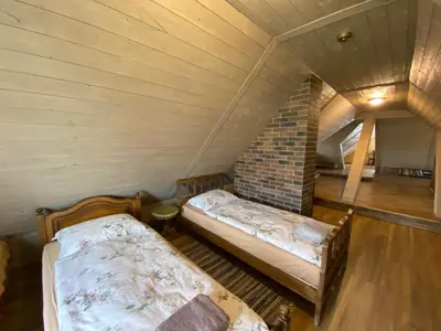 a room with two beds in a attic at Arbatinės apartamentai in Biržai