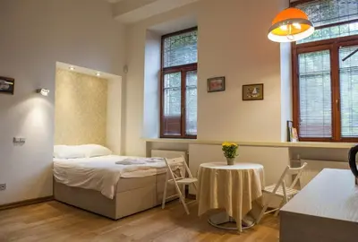 a bedroom with a bed and a table and chairs at Teatro Apartments in Vilnius