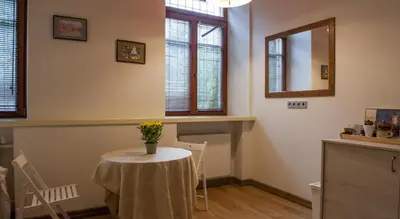 a dining room with a table with a vase of flowers on it at Teatro Apartments in Vilnius