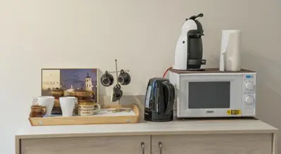 a counter with a microwave and a coffee maker on it at Teatro Apartments in Vilnius
