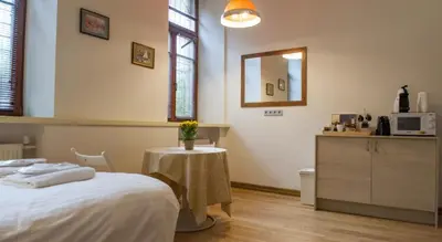 a bedroom with a bed and a table and a mirror at Teatro Apartments in Vilnius