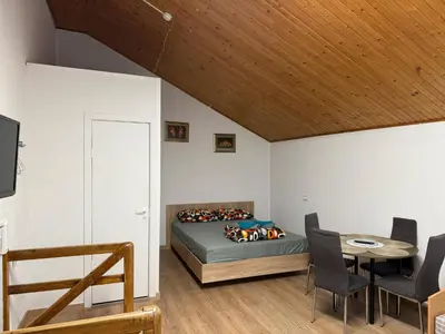 a bedroom with a bed and a table and chairs at Pasile in Kaunas