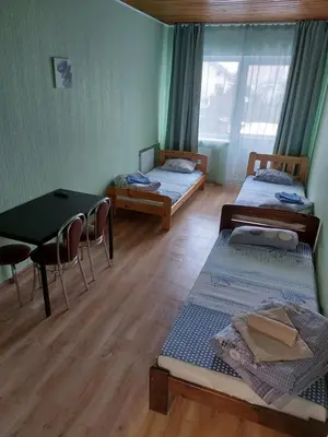 a room with two beds and a table and chairs at Pasile in Kaunas