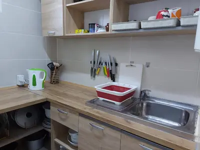 a kitchen sink with a red container on the counter at Pasile in Kaunas