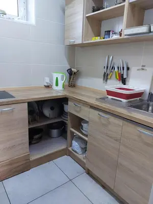 a kitchen with wooden cabinets and a counter with utensils at Pasile in Kaunas