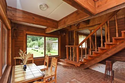 a dining room with a wooden staircase and a table at Rasos sodyba in Prienai