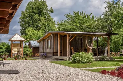 a log cabin with a porch and a gazebo at Rasos sodyba in Prienai