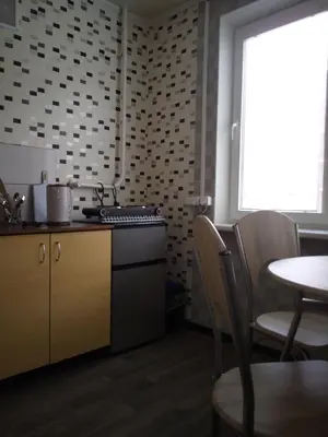 a kitchen with a stove and a table with chairs at Nakvynė Anykščių centre in Anykščiai
