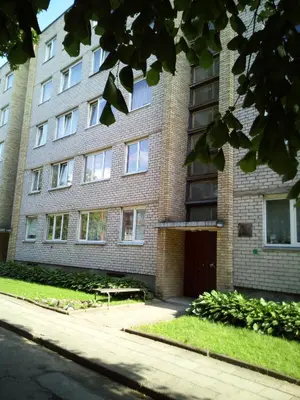 a brick building with a bench in front of it at Nakvynė Anykščių centre in Anykščiai