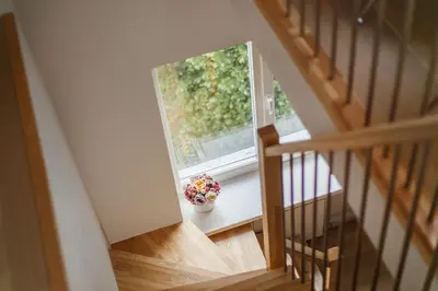 a staircase with a vase of flowers in a window at #stayhere 3BDR Modern & Stylish Apartment - Heart of Old Town by Houseys in Vilnius