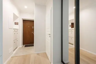 a hallway with white walls and a wooden door at #stayhere 3BDR Modern & Stylish Apartment - Heart of Old Town by Houseys in Vilnius