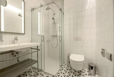 a bathroom with a shower and a toilet and a sink at Hotel Vilnia in Vilnius