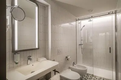 a bathroom with a sink and a toilet and a shower at Hotel Vilnia in Vilnius