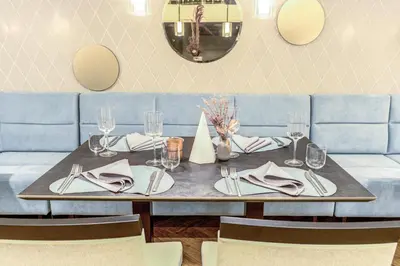 a table with plates and napkins on a blue couch at Hotel Vilnia in Vilnius