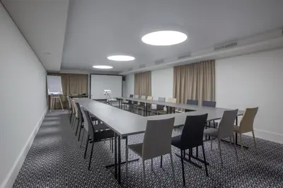 a conference room with a long table and chairs at Hotel Vilnia in Vilnius