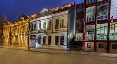 a building on the side of a street at night at Šaulys in Šiauliai