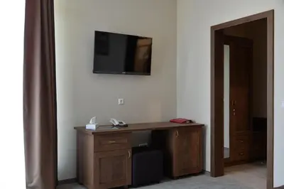 a room with a desk and a television on a wall at Šaulys in Šiauliai