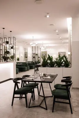 a dining room with a table and green chairs at Šaulys in Šiauliai