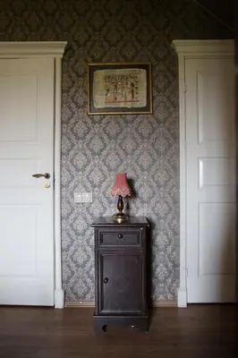 a room with two doors and a table with a lamp on it at Akmenių Dvaras in Akmeniai