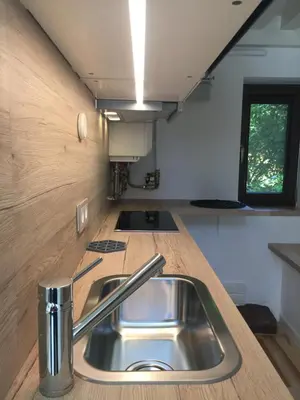 a kitchen with a sink in a tiny house at Jolie Apartments in Kaunas